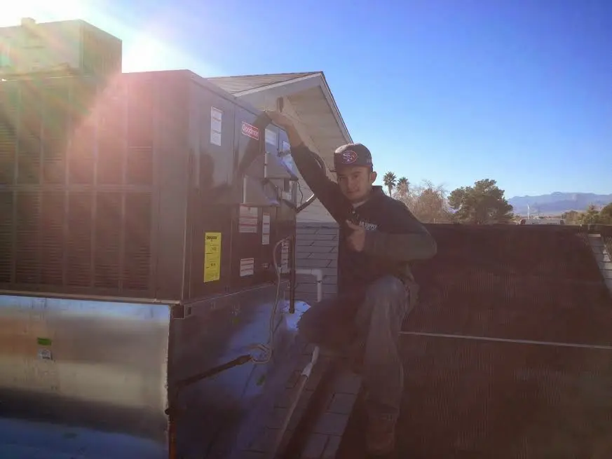 HVAC technician performing AC Tune-Up on a rooftop unit in Mabank